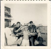Sitting for lunch at the beach with dad to his right, Jimmy Carney, and friends